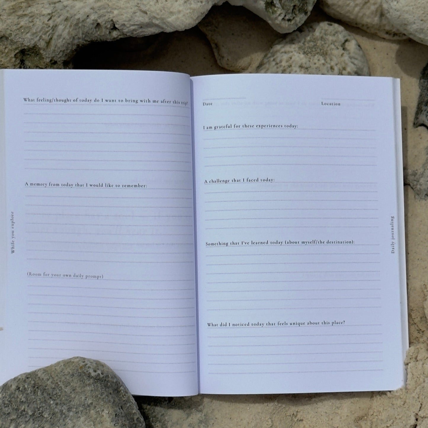Open travel journal on a bed of rocks and sand